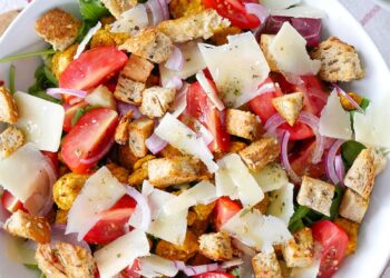 Смачний салат зі свіжих овочів, обсмаженої курки і хрустких сухариків