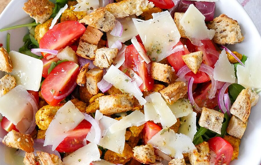 Смачний салат зі свіжих овочів, обсмаженої курки і хрустких сухариків
